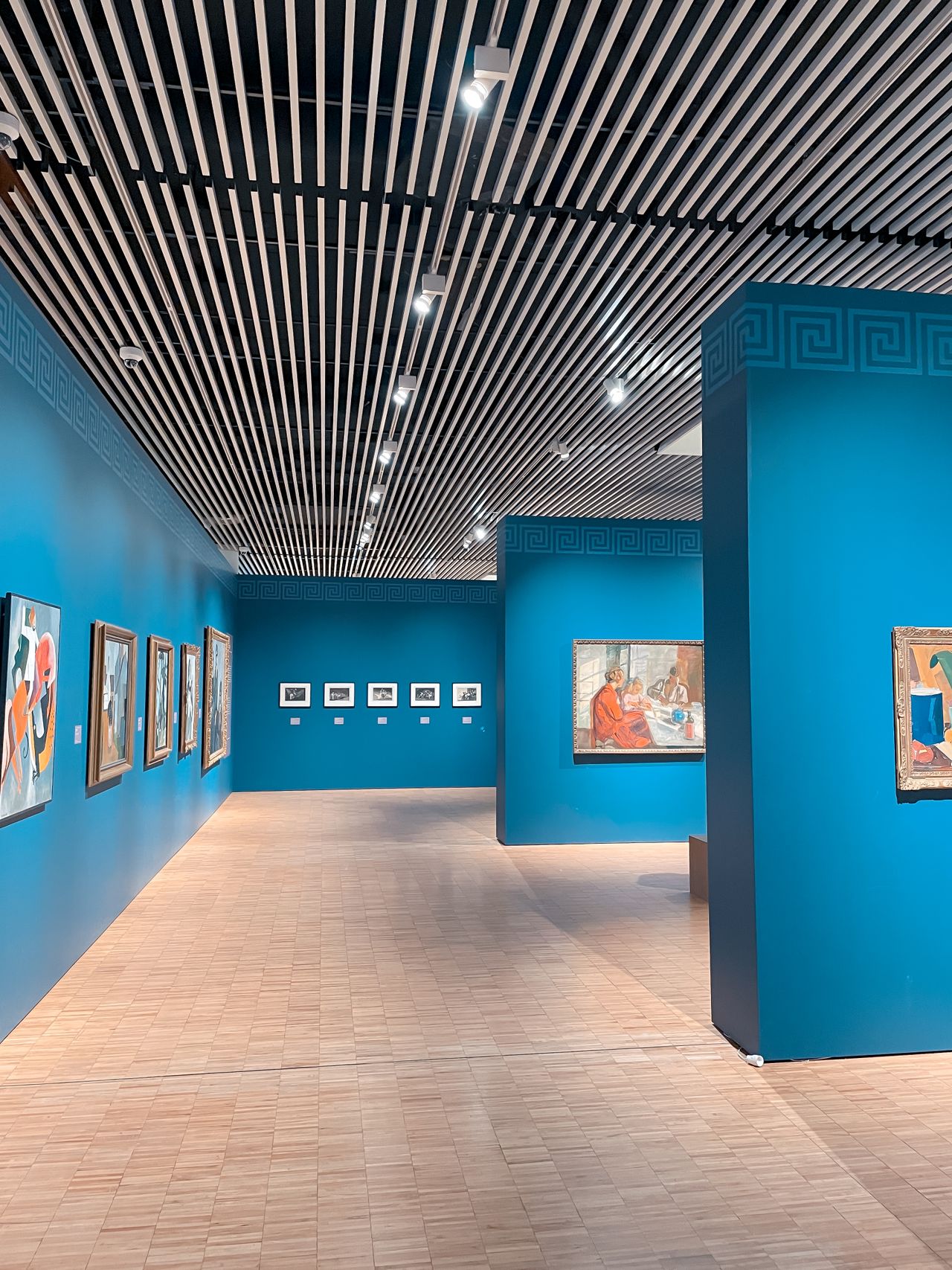 青い壁面に作品が展示された美術館の室内